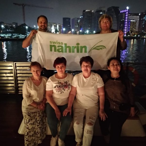 Поездка Свисс Нарин в ОАЭ 2020: группа с баннером Nahrin на вечерней прогулке